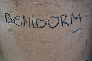 BENIDORM text carved stone sand beach destination sign tourism Spain Mediterranean coastal city name lettering