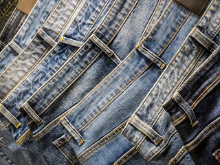 Denim jeans displayed in a retail setting showcasing various styles and shades of blue fabric