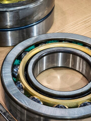 High-quality ball bearings displayed on a wooden surface with metallic components and green lubricant for industrial applications