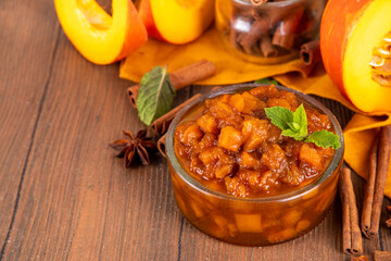 Homemade sweet autumn Pumpkin Chutney, with brown sugar, cinnamon, on white wooden background with ingredients for cooking - pumpkin squash, spices, honey