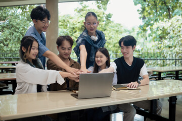 Happy study group of young diversity students demonstrating unity and encouragement before starting their group project