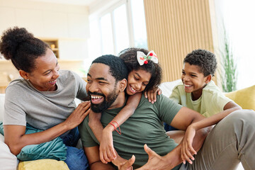Obraz premium Portrait of a happy black family mother father and kids at home on couch
