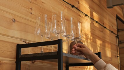 Daily routine with careful gesture glasses arranged by hand on wooden shelf rhythm of order...