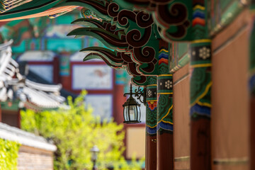 colorful wooden eaves with the hanging lamp at the traditional Korean building in the Buddhist temple