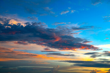 Cumulus sunset clouds with sun setting down on dark background.orange cloud sky and blue sky. Beautiful sky.