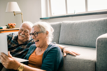 Happy seniors using laptop together
