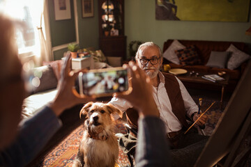 Elderly man with dog taking a photo
