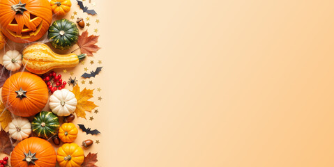 Assorted pumpkins, a jack-o'-lantern, autumn leaves, and confetti on an orange background with copy space