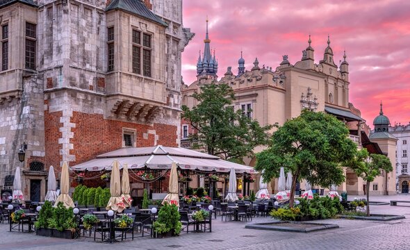 Rynek Gł&oacute;wny w Krakowie z Kościołem Mariackim, Sukiennicami i Ratuszem o wschodzie słońca.