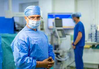 Medical specialist in operating room with surgical gloves. Surgeon in hospital wearing protective clothing and gloves preparing for medical procedure.