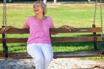 Portrait Happy Senior Woman Sitting Outside on a Bench Laughing