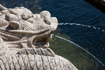 stone sculpture fountain with water streams at the Buddhist temple