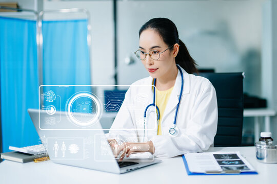 Asian female doctor using AI technology on laptop in hospital lab. Modern healthcare, digital innovation, medical data analysis, and smart diagnosis with real people concept.