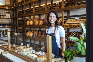 Bakery Shop Assistant With Fresh Bread Behind Glass Counter, Smiling Woman