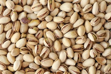 Tasty unpeeled pistachios as background, top view flat lay background