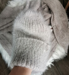 Handmade cozy knitted accessories in soft pastel tones. Winter fashion collection, slow fashion and handmade design. Angora hat and scarf. Knitting wool texture background