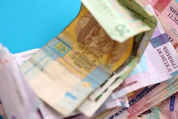 Ukrainian money bills on light blue paper background
