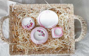 Top view of scented candles in basket, close-up on wrapping paper background, handmade concept