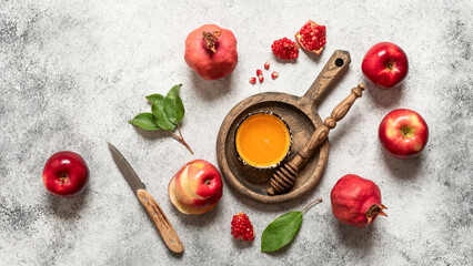 Honey, apples and pomegranate on a light rustic background. Jewish New Year, Rosh Hashanah. Top view, flat lay
