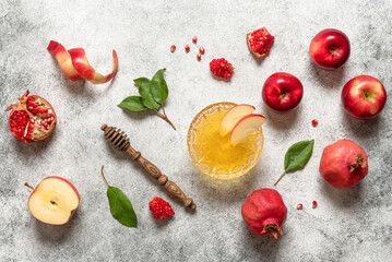 Apples, honey, and pomegranates on a light grunge background, top view. Rosh Hashanah holiday.