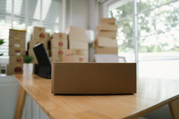 A person checking inventory with a tablet and notebook in a warehouse, surrounded by stacked...