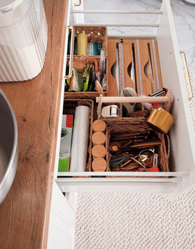 Organized kitchen drawer with eclectic gadgets whispers tales of culinary alchemy, Hygge coziness, and National Kitchen Witch Day magic