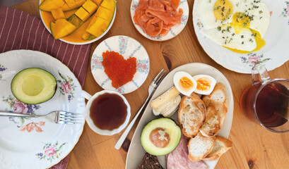 A vibrant breakfast tapestry features avocado, salmon, and caviar, blending Nordic Midsummer and Diwali's abundant flavors
