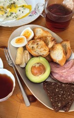 Aromatic brunch tableau featuring avocado with egg, rye bread, ideal for World Food Day and International Breakfast Month