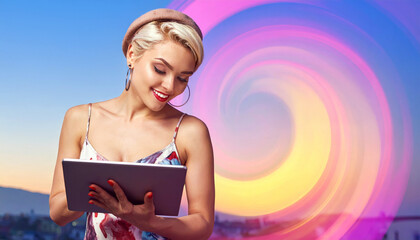 Stylish young woman in a summer dress and beret is smiling while looking at a tablet.