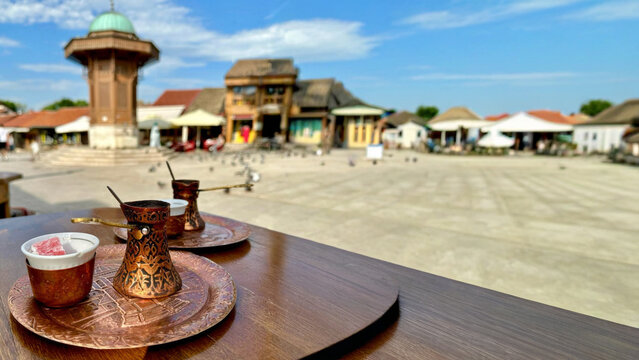 Copper cups glint in Bosnian bazaar's sunlit square, echoing whispered secrets of Bajram celebrations and Ottoman nostalgia