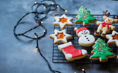 "Christmas Cookie Display Featuring Trees, Stars, Snowmen, Reindeer, Stockings, and Fairy Lights, Festive Holiday Treats with Colorful Icing on Cooling Rack for Seasonal Baking, Winter Decor.