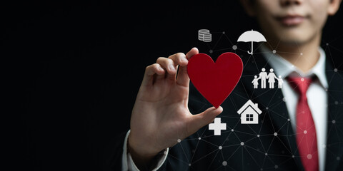 Concept of insurance and protection with businessman holding red heart symbol, representing love,...