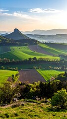 Rolling hills, vibrant green fields, mountain peak