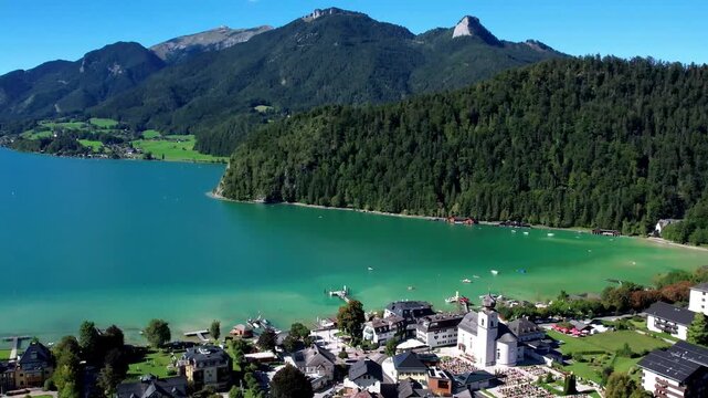 Turquoise Lake Wolfgangsee in the Salzkammergut region of Austria and scenic village Stroble, breathtaking mountains scenery. Austrian tourism and boat cruises. 4k hd footage
