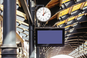 Train station clock and blank digital display board. Transportation hub with timetable indicator. Modern public infrastructure design for travel and passenger information in urban railway system.