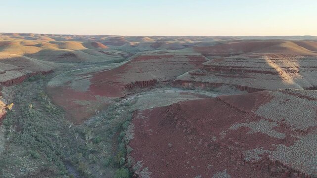 aerial drone shot of a remote bush camp along secluded George river in the beautiful red rolling hills of Millstream Chichester National Park, pilbara shire in West Australia.
