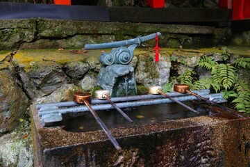 Ceremonial water ablution spring in chozuya water basin of Fushimi Inari Taisha shrine in Kyoto, Japan.