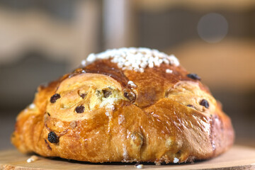 Golden raisin brioche with pearl sugar topping on a wooden board, a traditional sweet bread from...