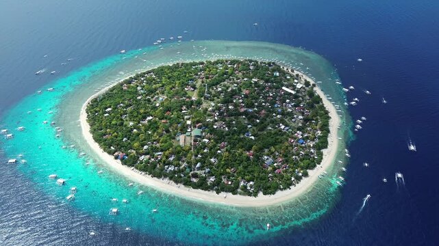 Aerial top view of tropical island Balicasag surrounded by turquoise waters and coral reefs, Philippines, 4k