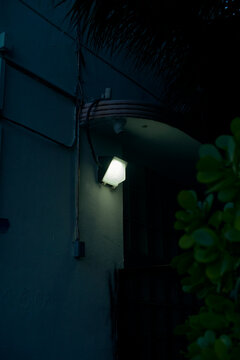 Dimly lit building entrance with a glowing wall lamp at night. Miami, Florida, USA