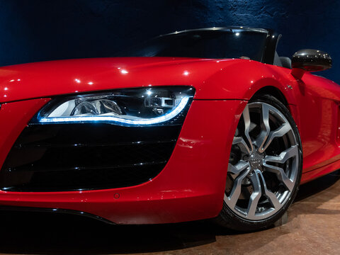 Red Audi R8 Spyder V10 low angle front view, Dynamic studio shot of a german convertible supercar


