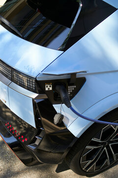 Electric car charging at a station with a focus on the rear section and charging cable. Stuttgart, Germany