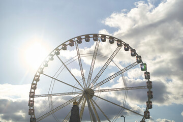 Large Ferris wheel against a cloudy sky with sunlight shining through. Brussels, Belgium