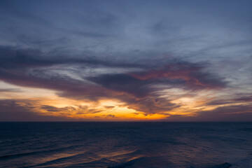 Dramatic sunset over the ocean with vibrant orange and dark clouds in the sky. Ke Ga, Binh Thuan, Indonesia