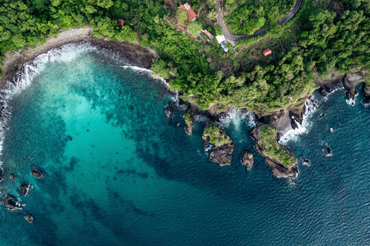 Aerial view of a lush green coastline with turquoise waters and rocky outcrops. Paya, on We Island in Aceh, Sumatra, Indonesia