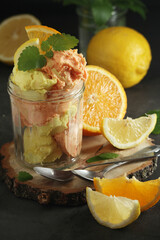 Lemon and orange ice cream scoops in glass jar