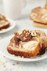 A piece of marble biscuit with chocolate cream and nuts	