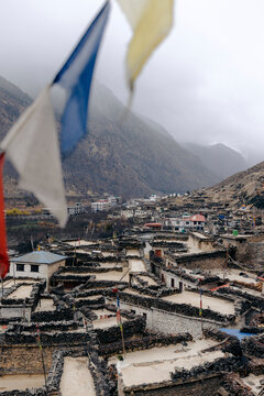 Mountain village with stone houses, prayer flags, and misty mountains in the background. Marpha, Annapurna, Mustang District of the Gandaki Province, Nepal