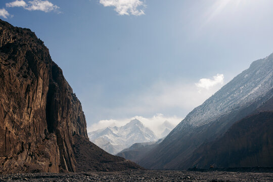 Majestic mountains under clear blue skies with rugged cliffs framing a distant snow peak. Road F042, Annapurna, Mustang District, Gandaki Province, Nepal