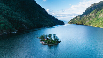 Lovrafjorden captivates with its stunning panorama, featuring a peaceful island dotted with lush greenery and a charming cabin. This picturesque location invites exploration and relaxation.